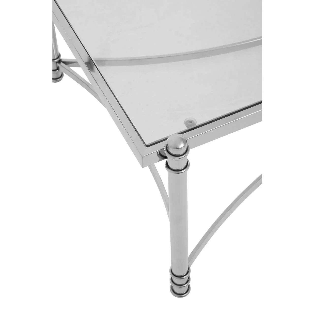Close view of glass coffee table with chrome frame and decorative corner legs