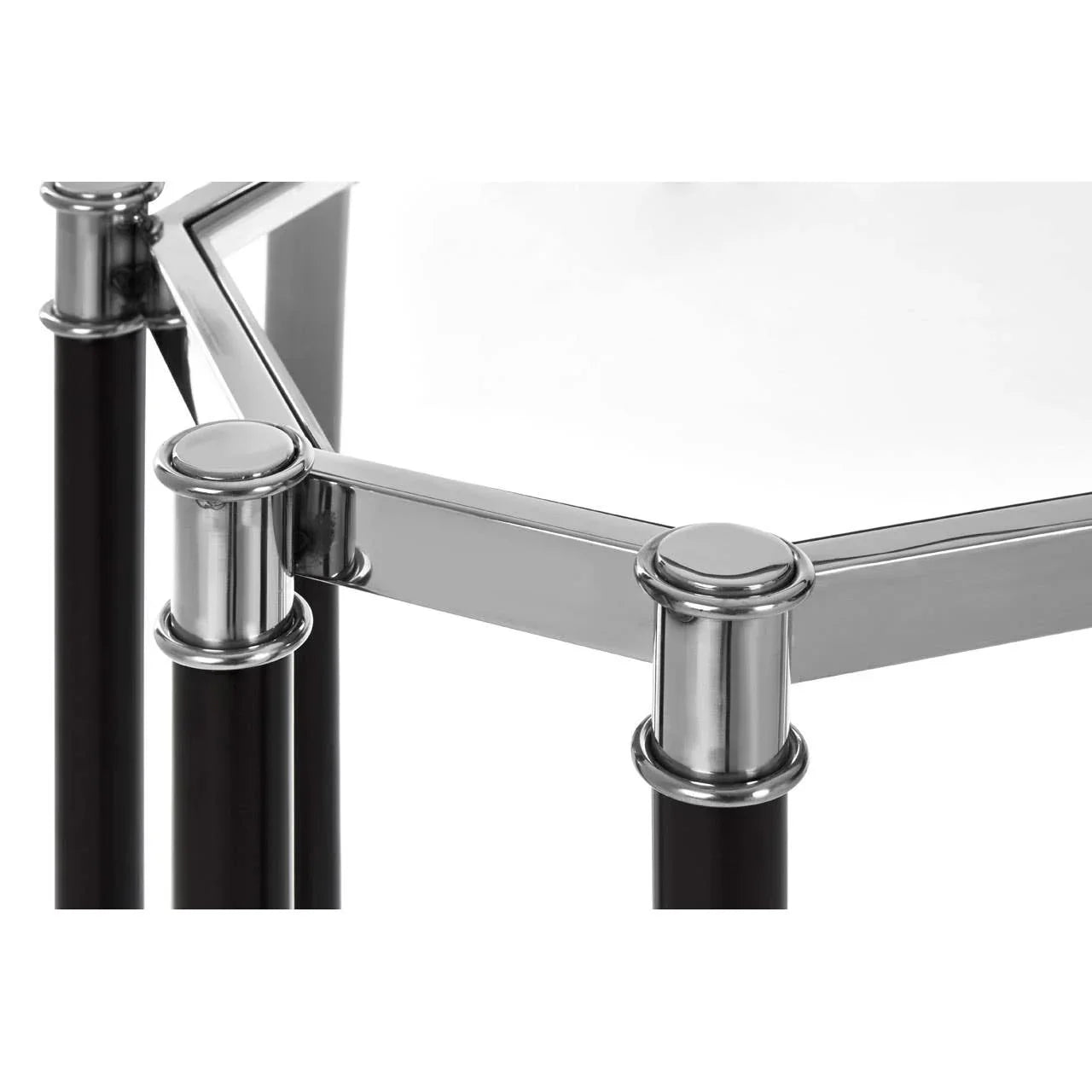 Chrome and black metal side table corner with glass top, close-up of frame detail