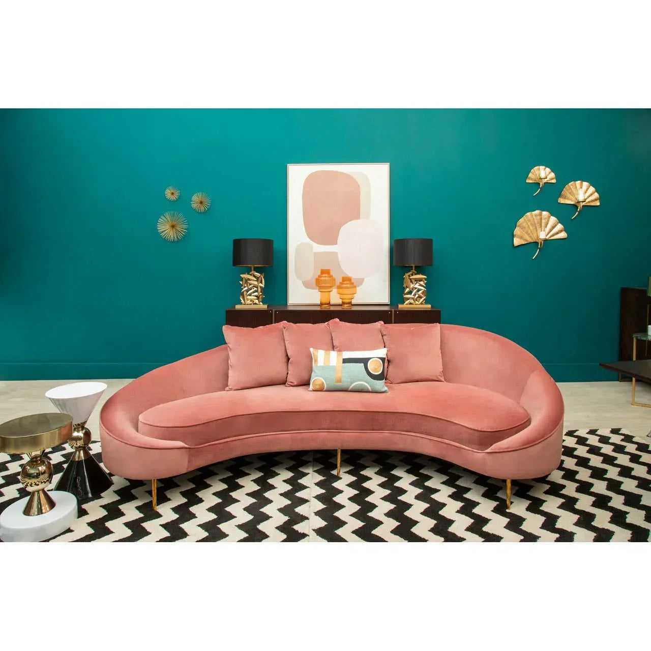 Pink velvet sofa with gold legs in modern living room, placed on black and white zigzag rug