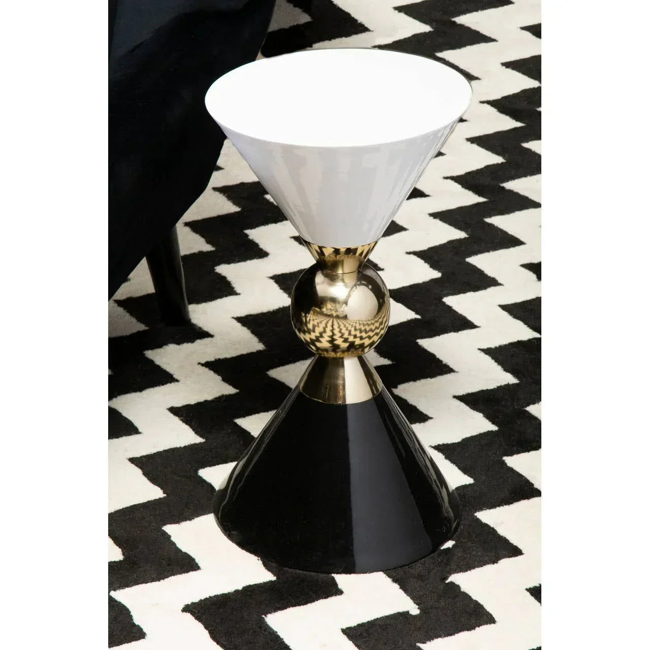 Modern side table with black and white geometric design on patterned rug