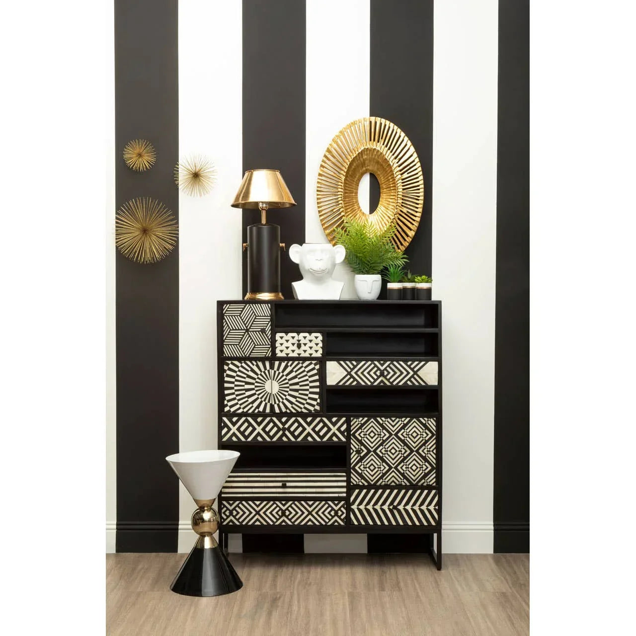 Geometric patterned black and white chest of drawers with gold decor accents in modern room