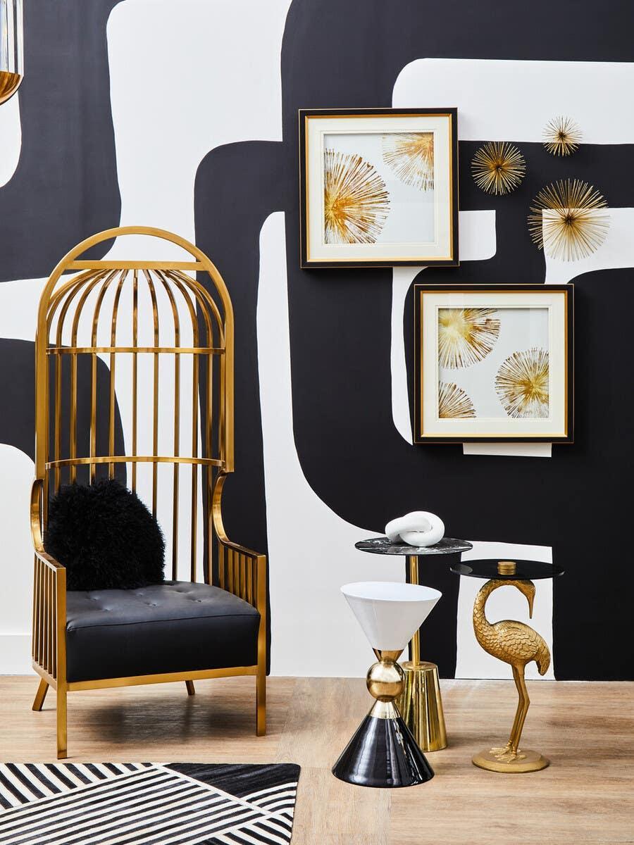 Gold accent chair with black cushion, eclectic side tables, wall art, modern black and white decor