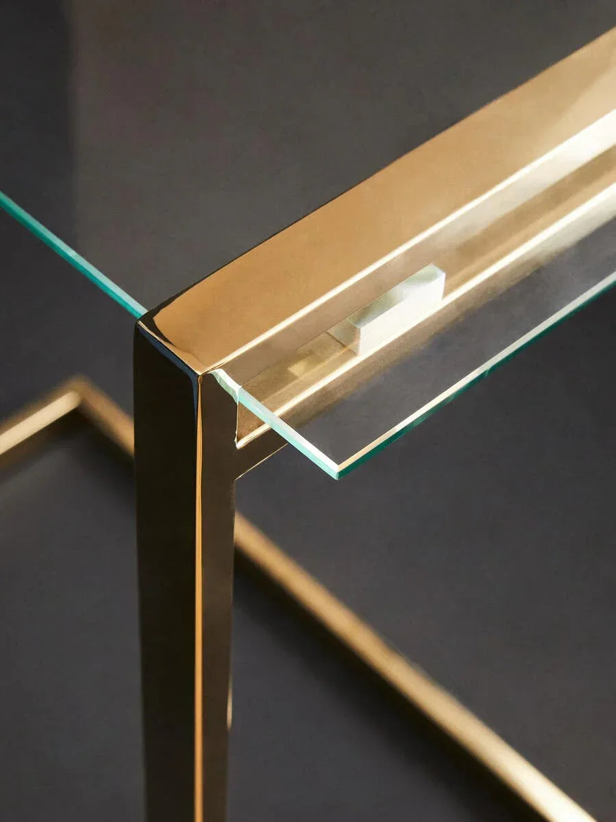 Glass top side table with gold metal frame, close-up of corner and leg detail