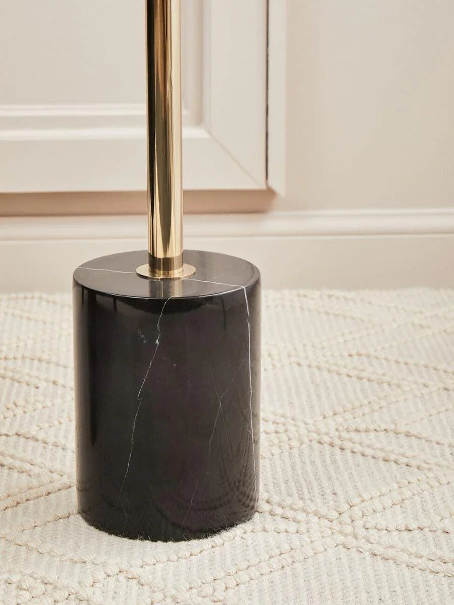Black marble lamp base with gold metal stand on cream textured rug