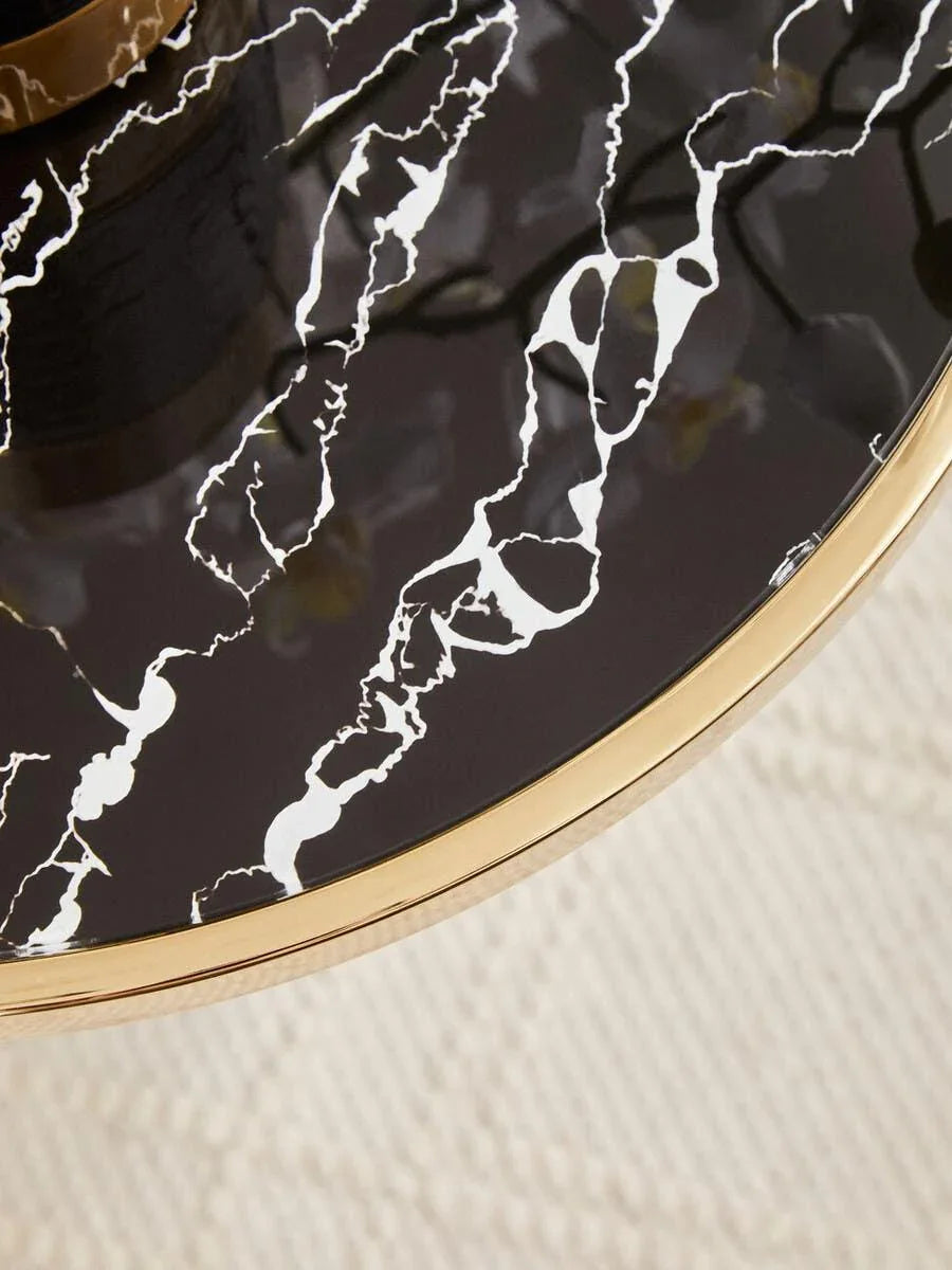 Black marble coffee table top with gold metal edge detail, close-up view