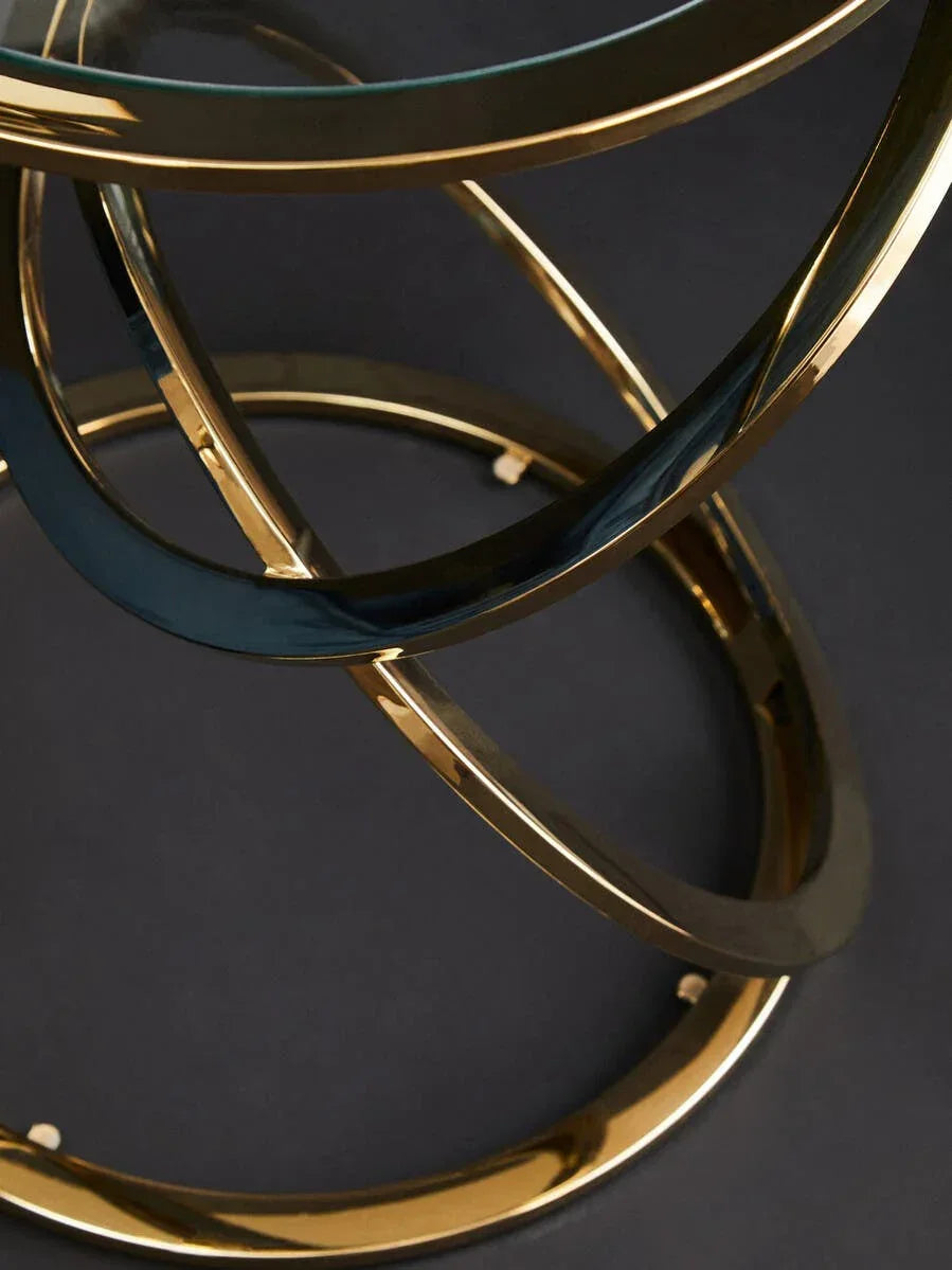Round glass coffee table with gold metal base, modern circular frame close-up