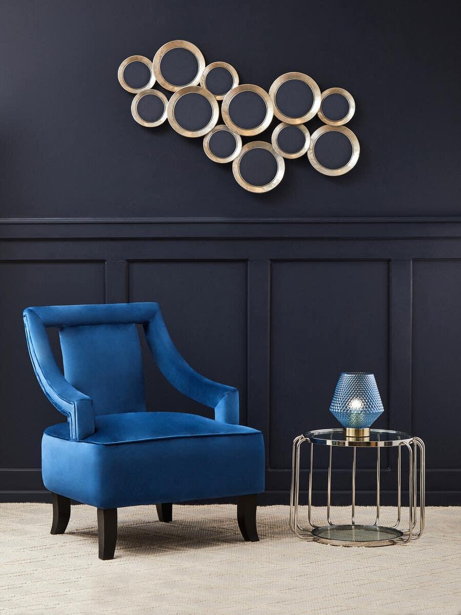 Blue velvet accent chair with side table and geometric lamp in modern living room