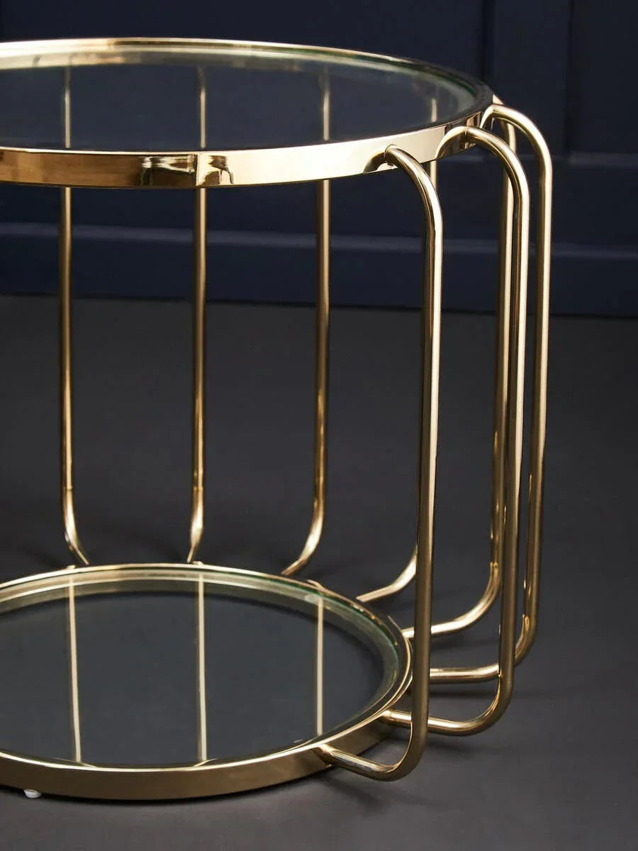 Round glass coffee table with gold metal frame and lower shelf