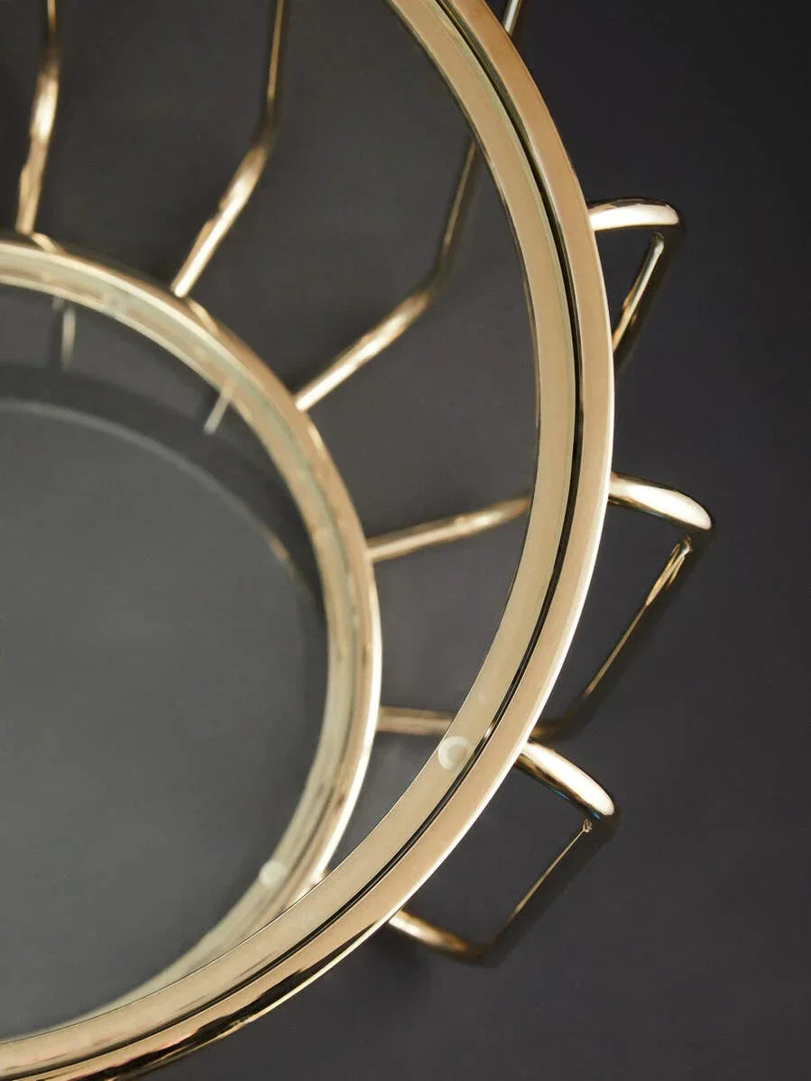 Gold metal and glass coffee table with geometric frame, close-up of surface detail