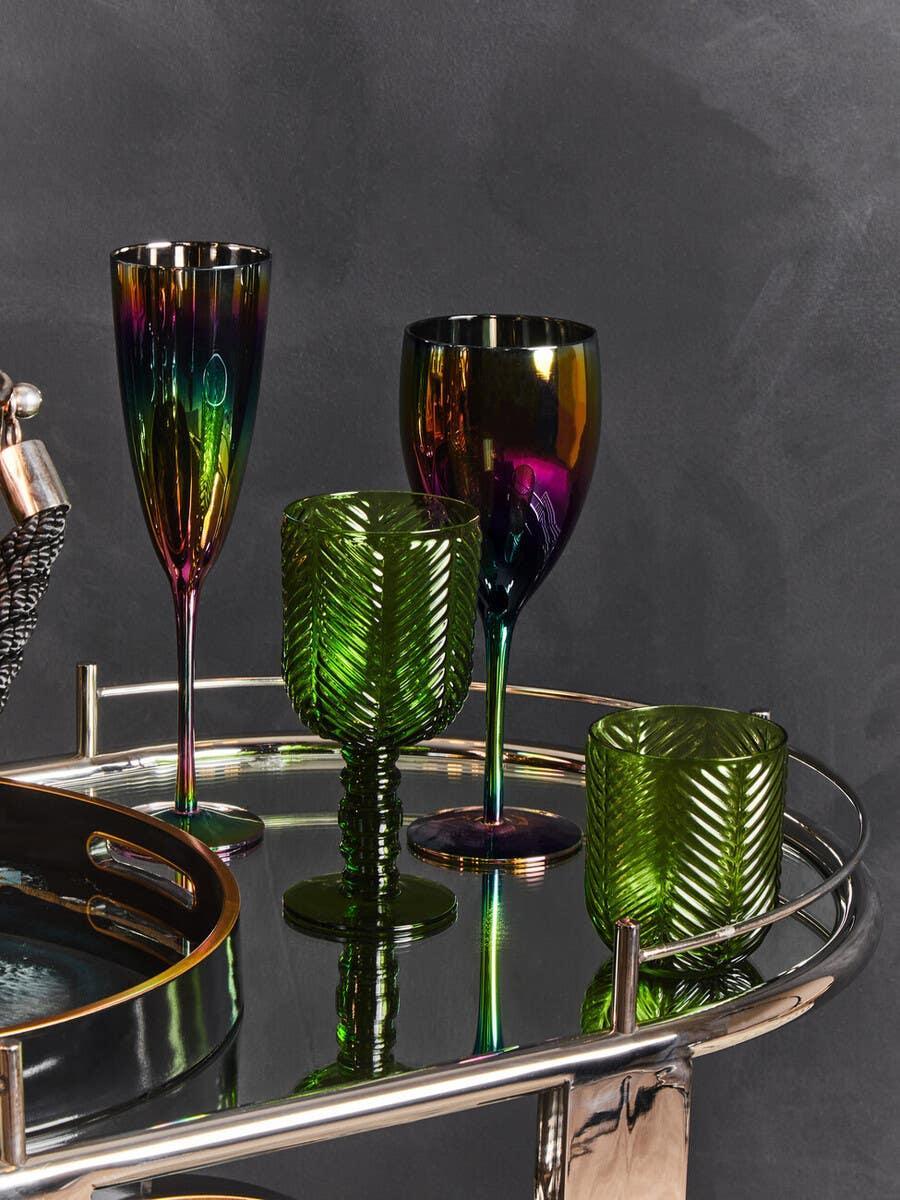 Green textured glassware and iridescent wine glasses on mirrored drinks trolley
