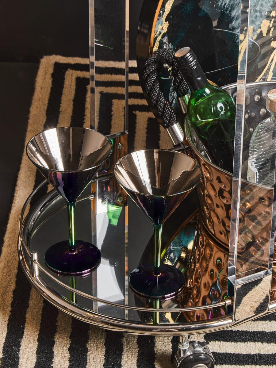 Glass and chrome drinks trolley with two martini glasses and a wine bottle on mirrored tray