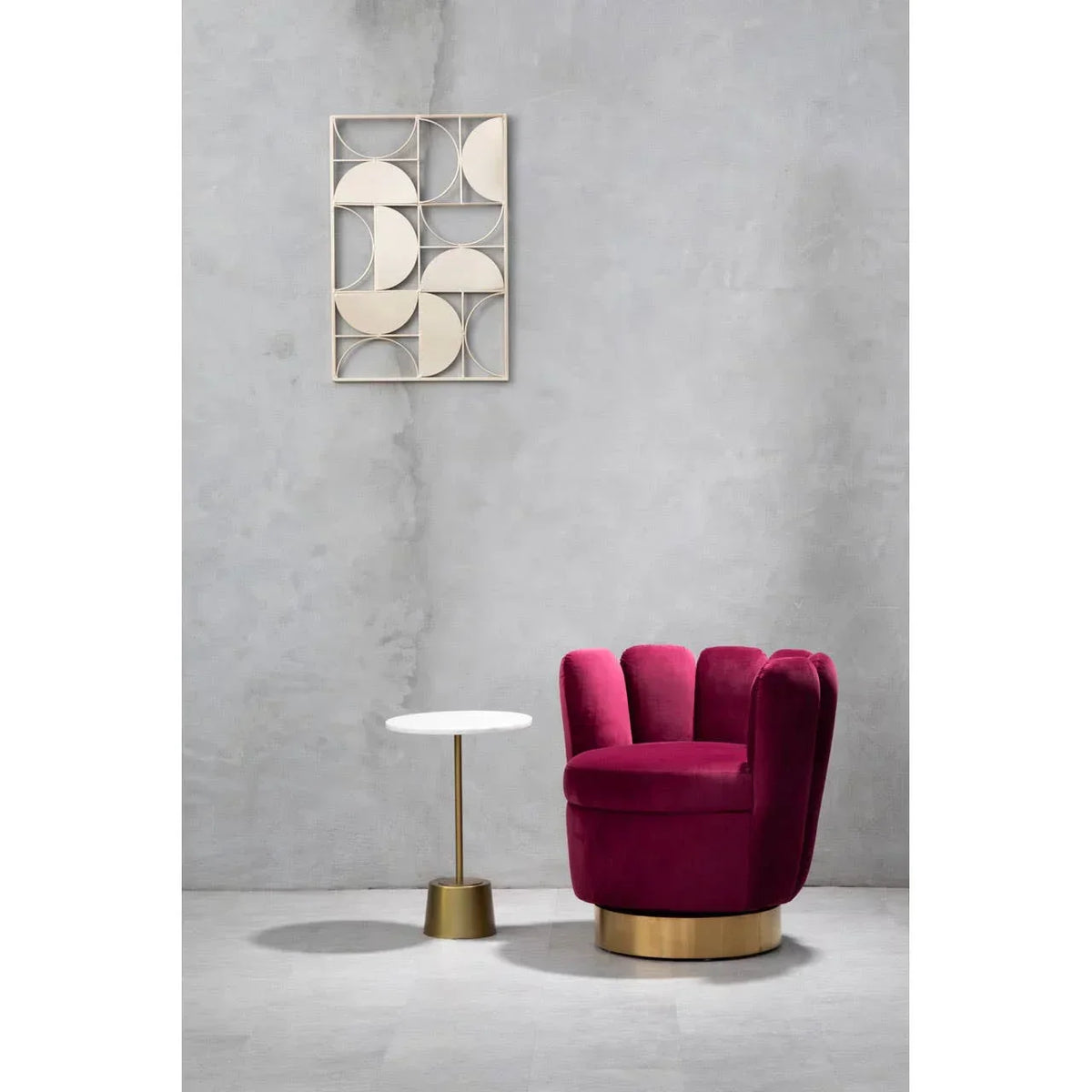 Velvet accent chair with gold base beside round side table in modern living room