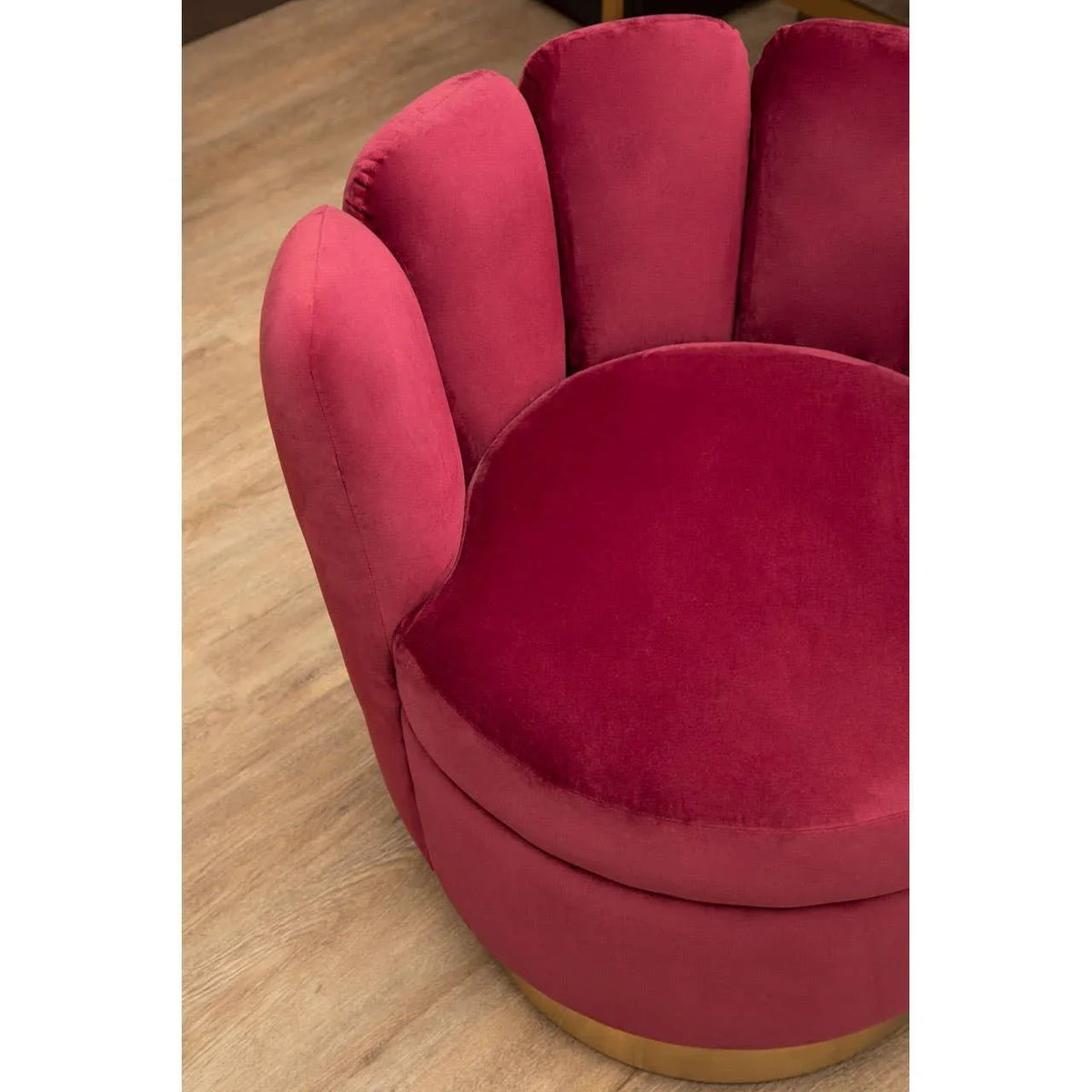 Red velvet scalloped accent chair with gold base on wooden floor