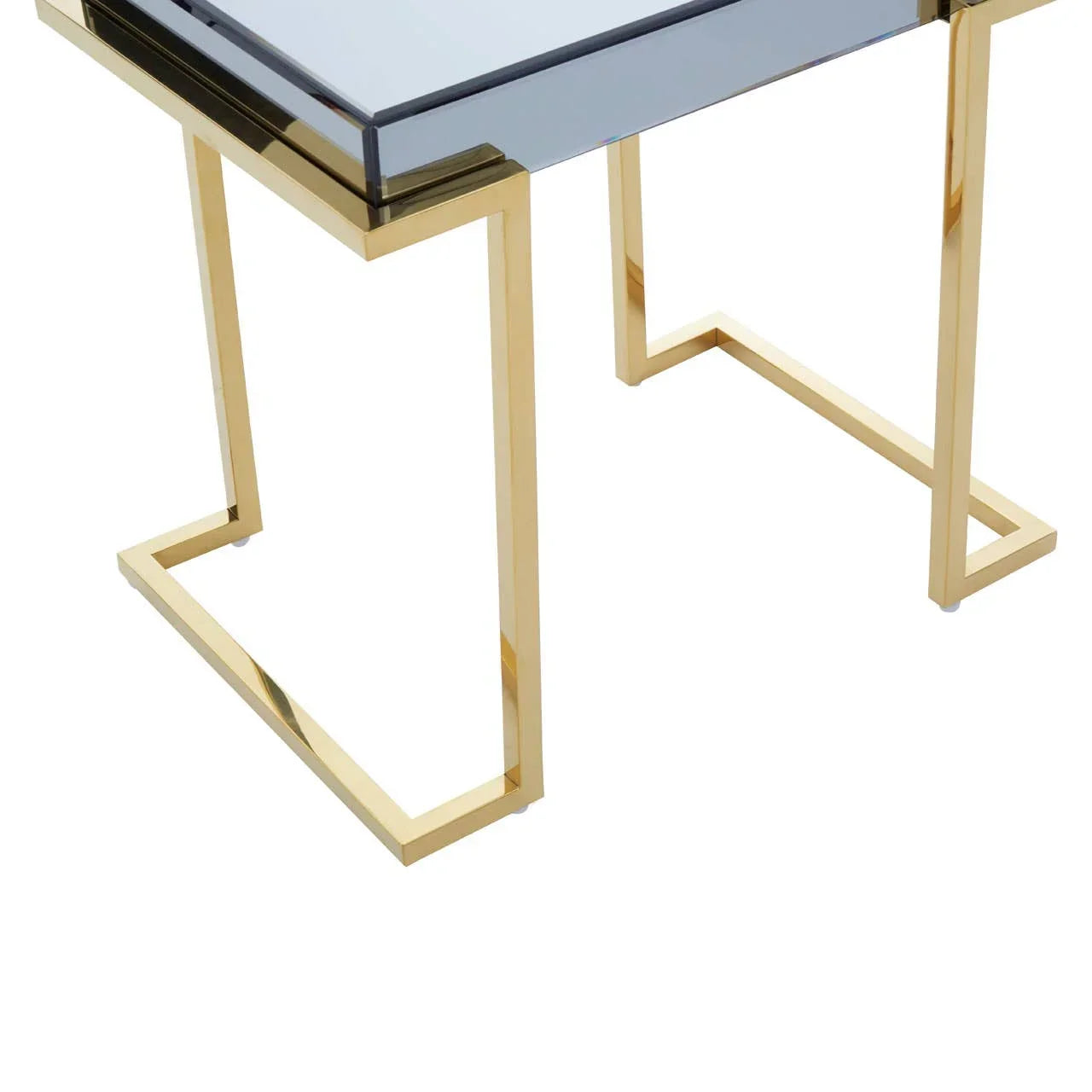 Glass top side table with gold metal legs, geometric design, close-up corner view