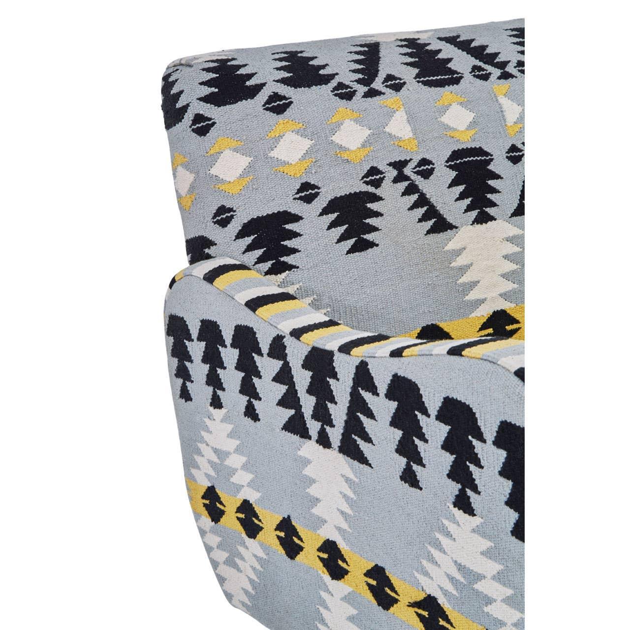 Close-up of patterned armchair with blue, black, yellow and white geometric upholstery