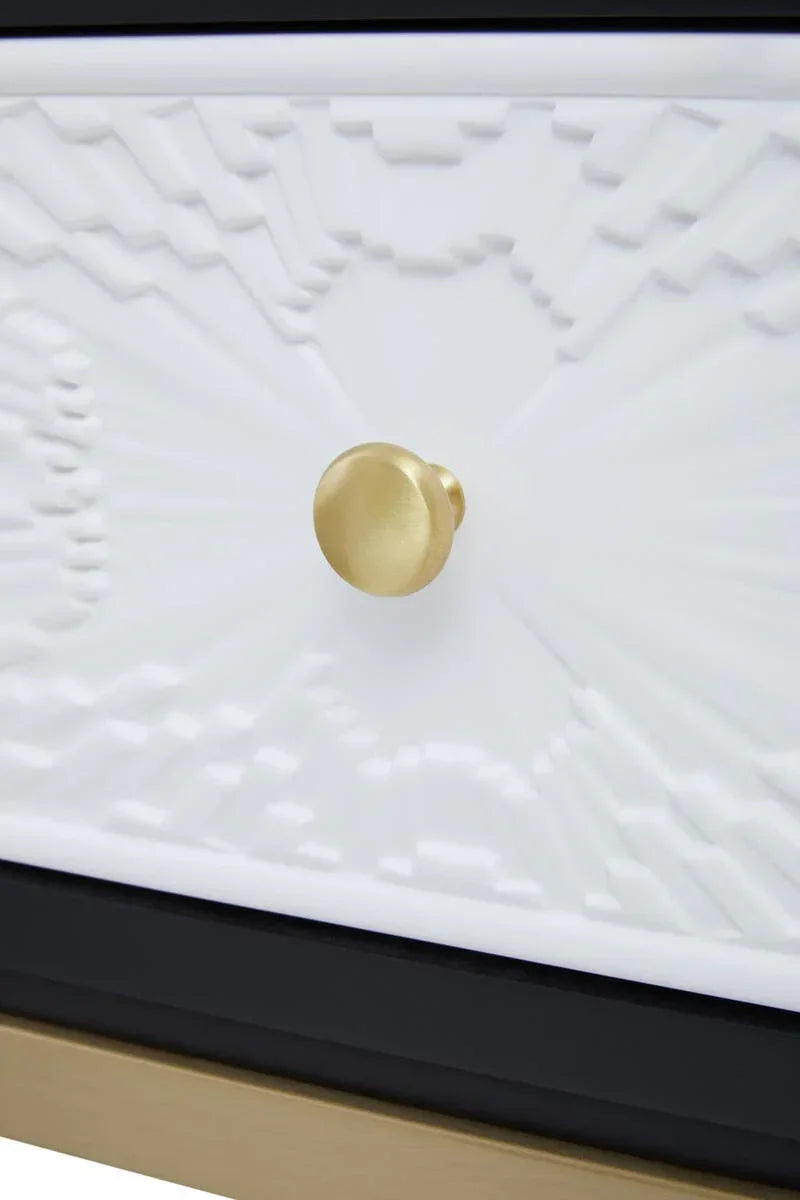 Gold metal drawer knob on textured white furniture front with geometric pattern
