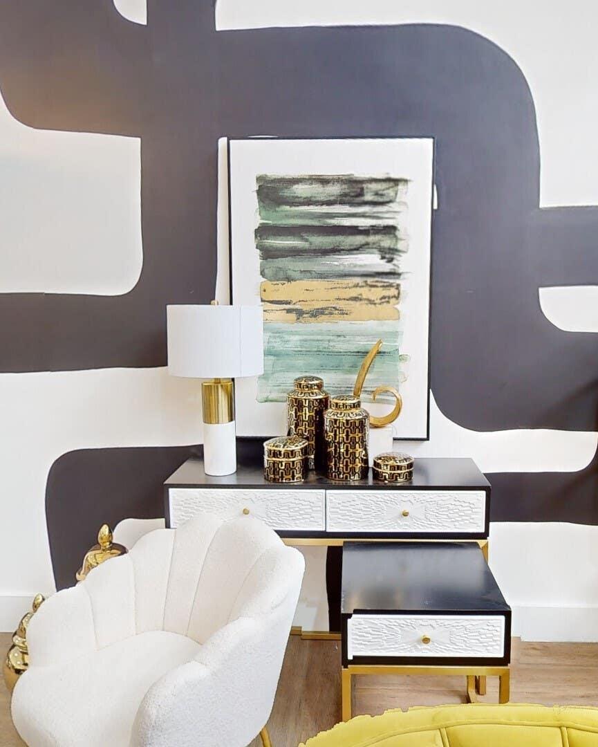 Modern accent chair and black console table with gold decor in stylish living room setup