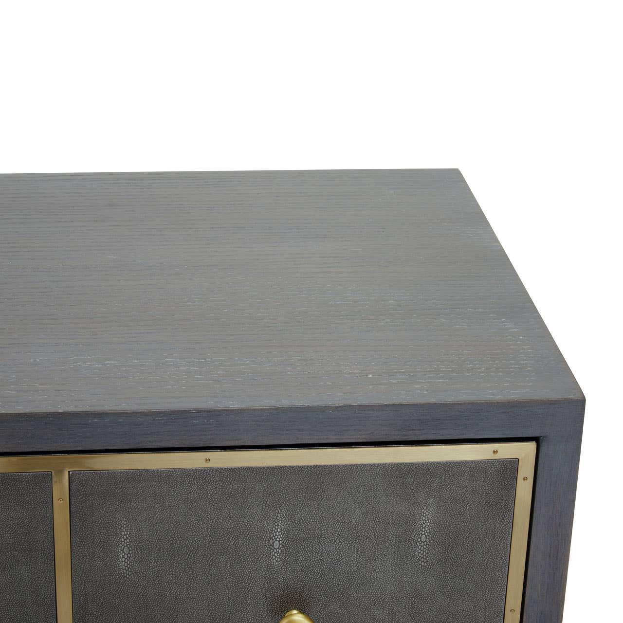 Grey wood sideboard with brass trim and textured drawer front, close-up corner view