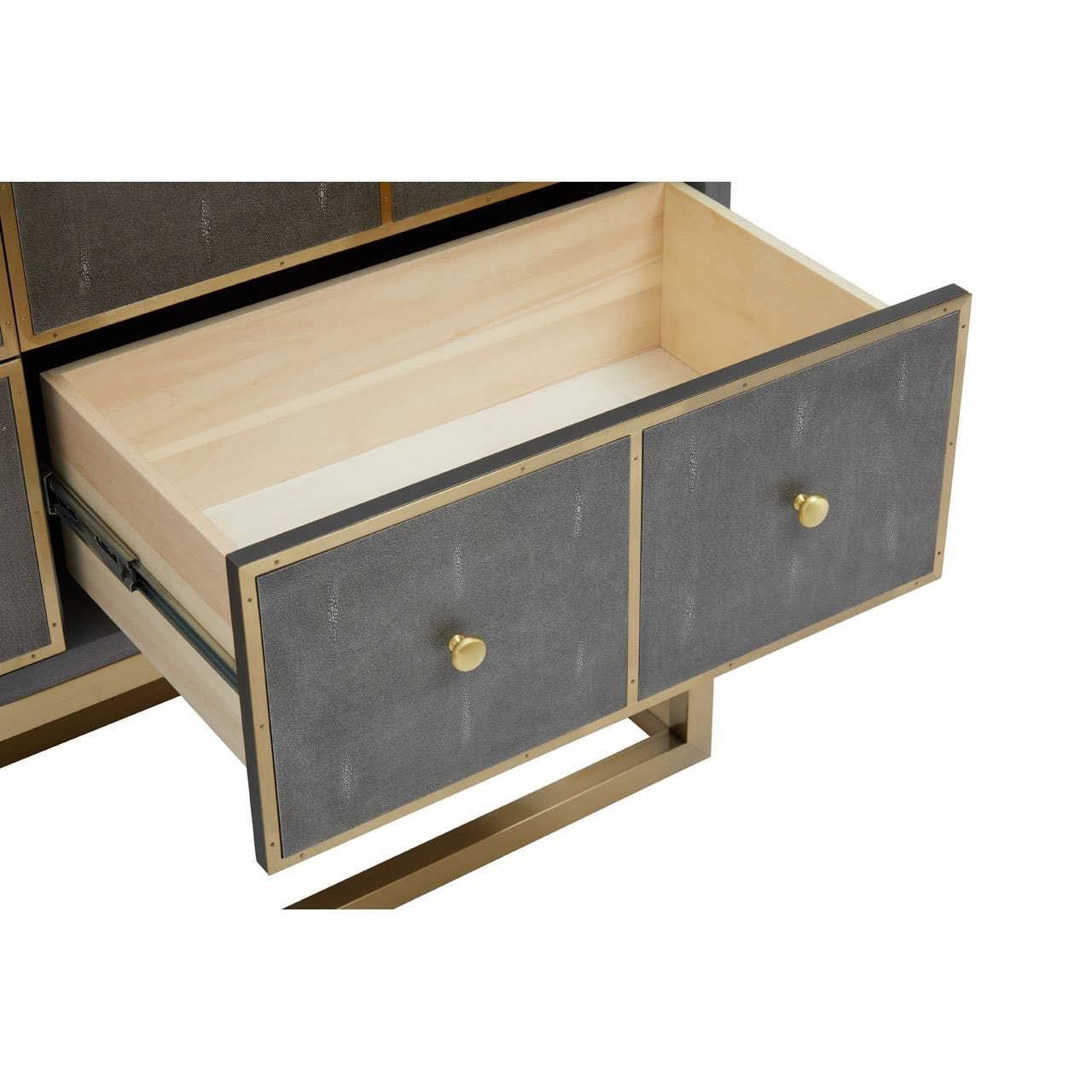Grey and gold chest of drawers with open drawer showing light wood interior