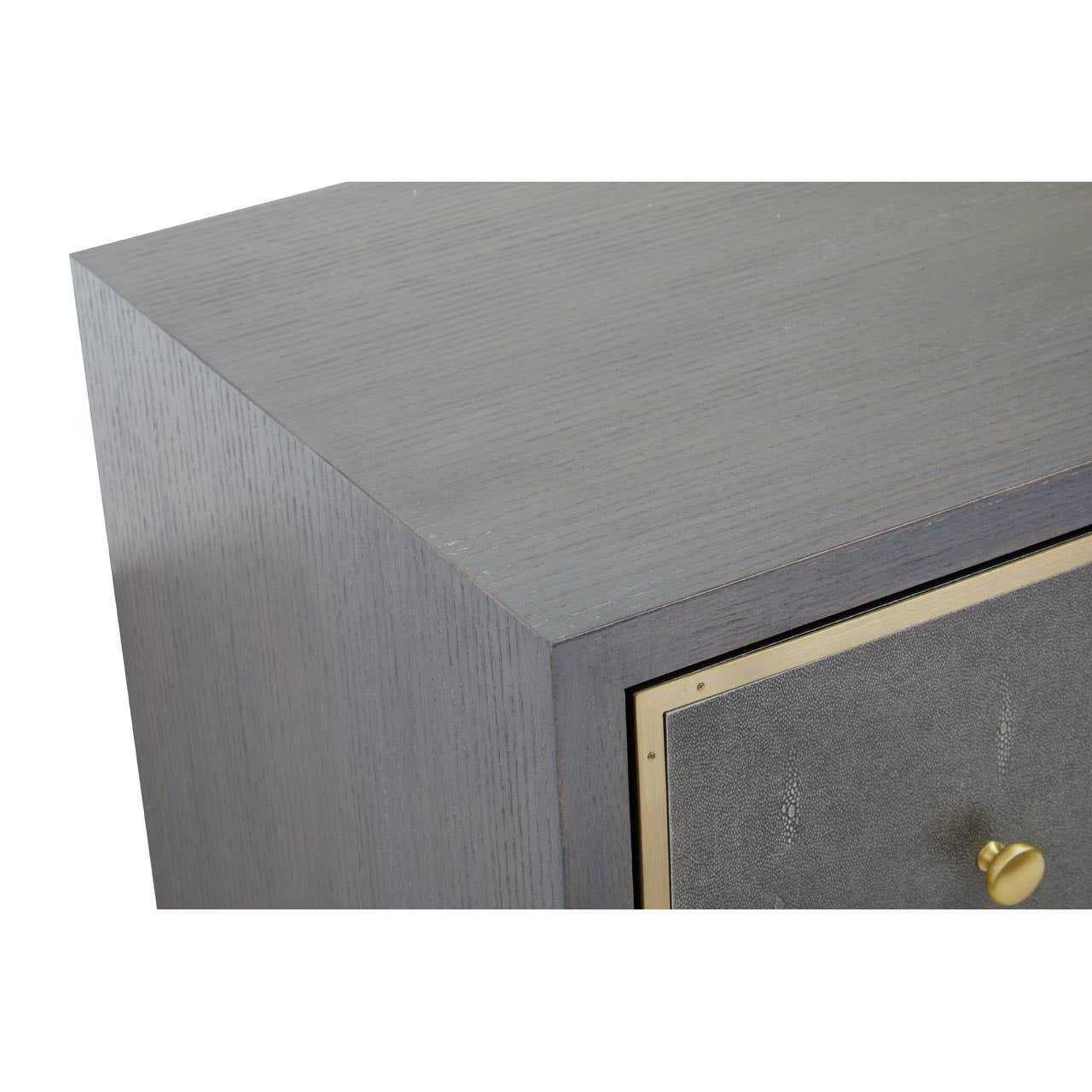 Close up of grey wood bedside table with gold drawer knob and trim