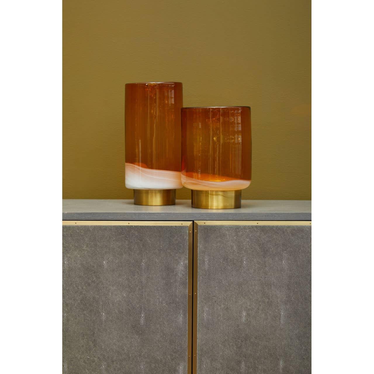 amber and white glass vases with gold bases on modern sideboard