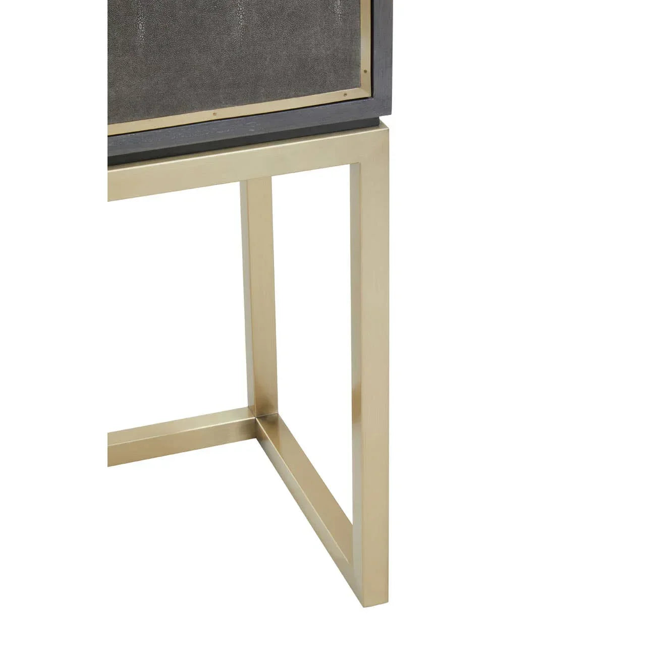 Close-up of brass metal console table leg with dark textured panel detail