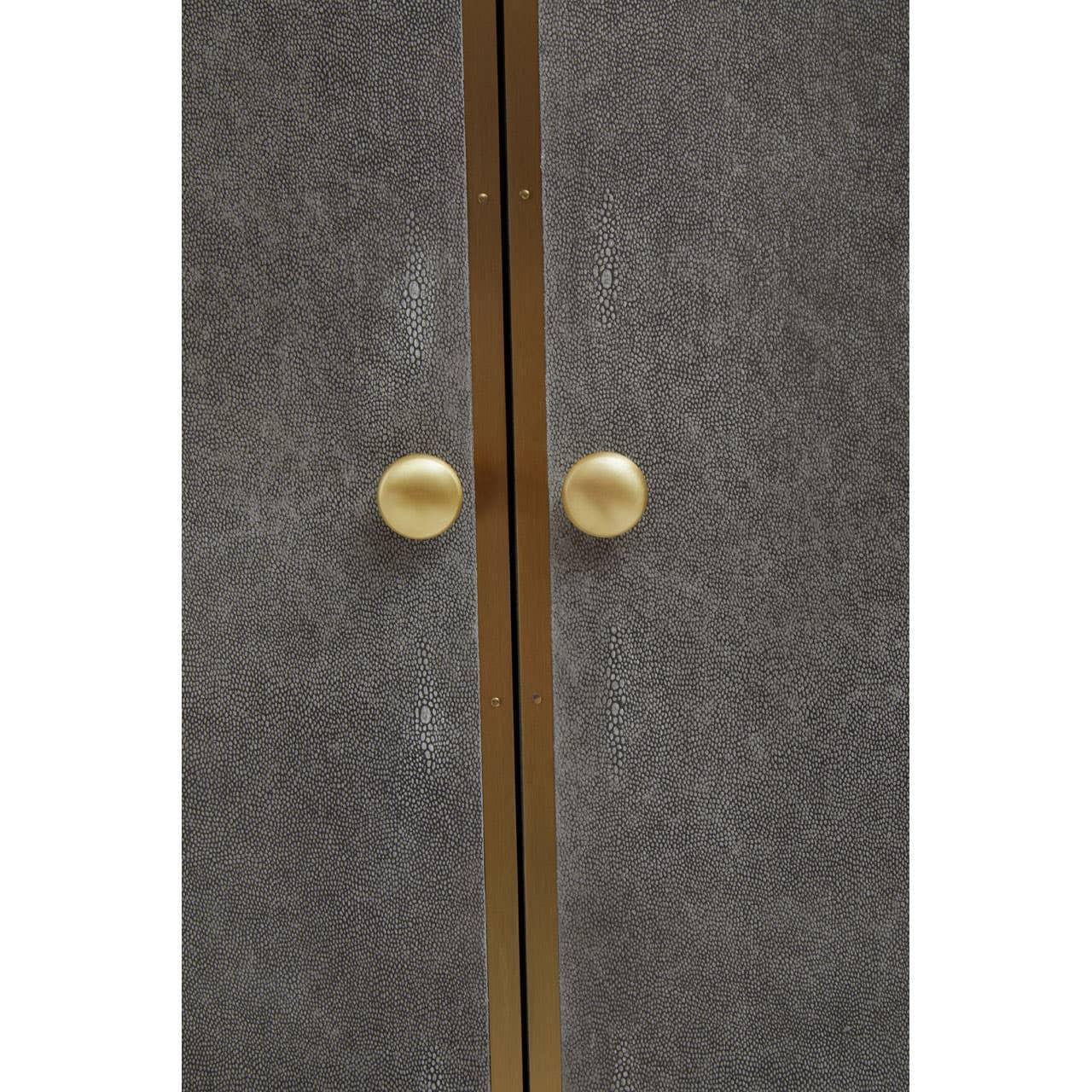 Textured grey cabinet doors with gold handles and brass trim