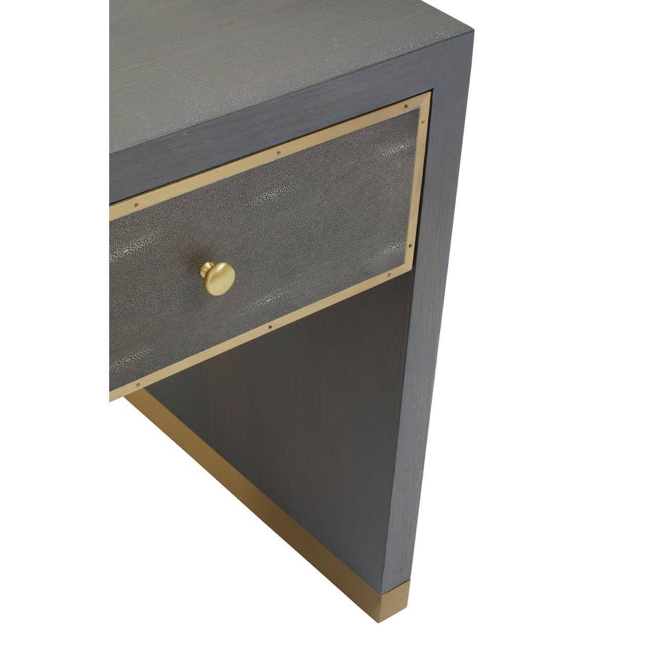 Grey wood console table corner with gold trim and textured drawer front