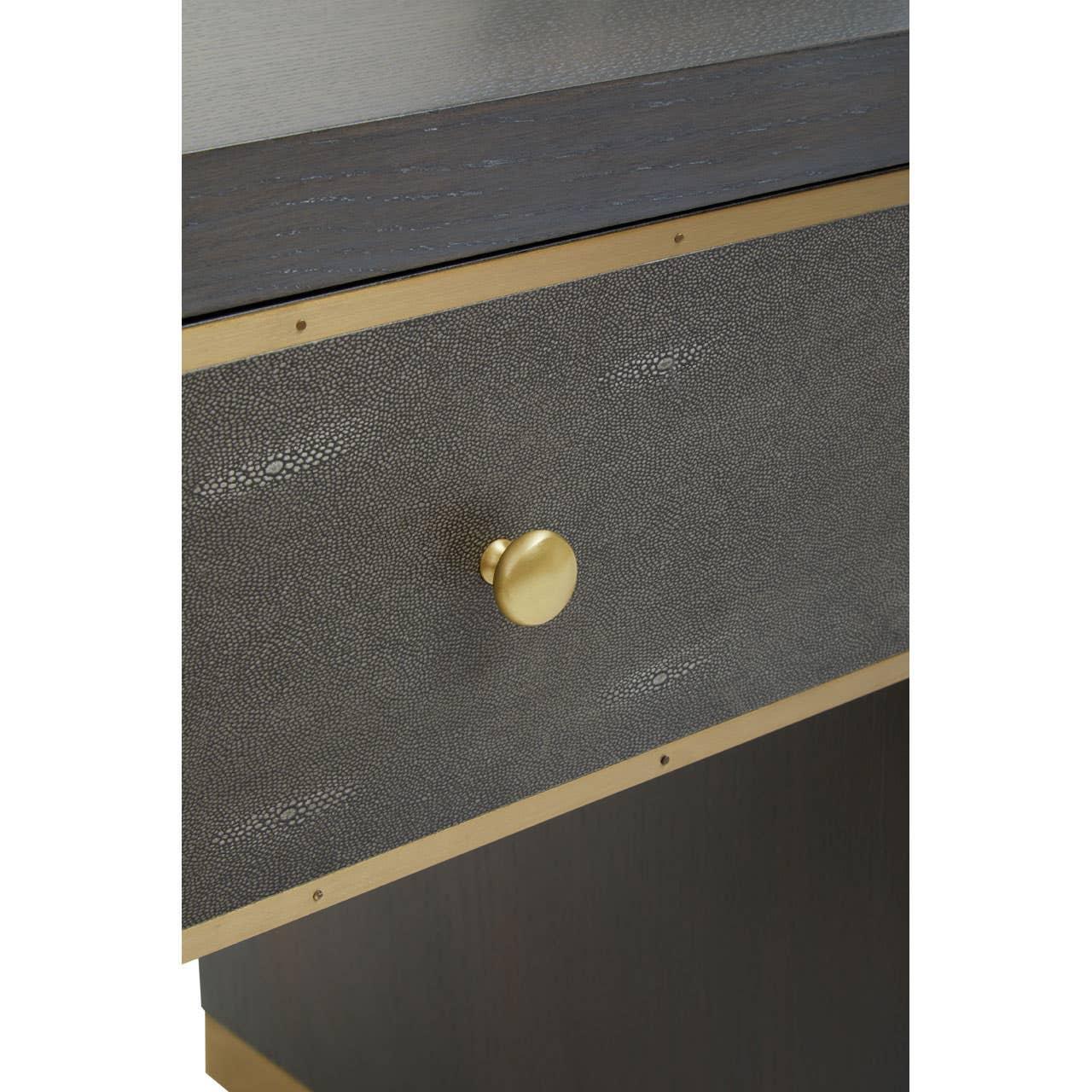 Close up of textured bedside table drawer with brass handle and trim