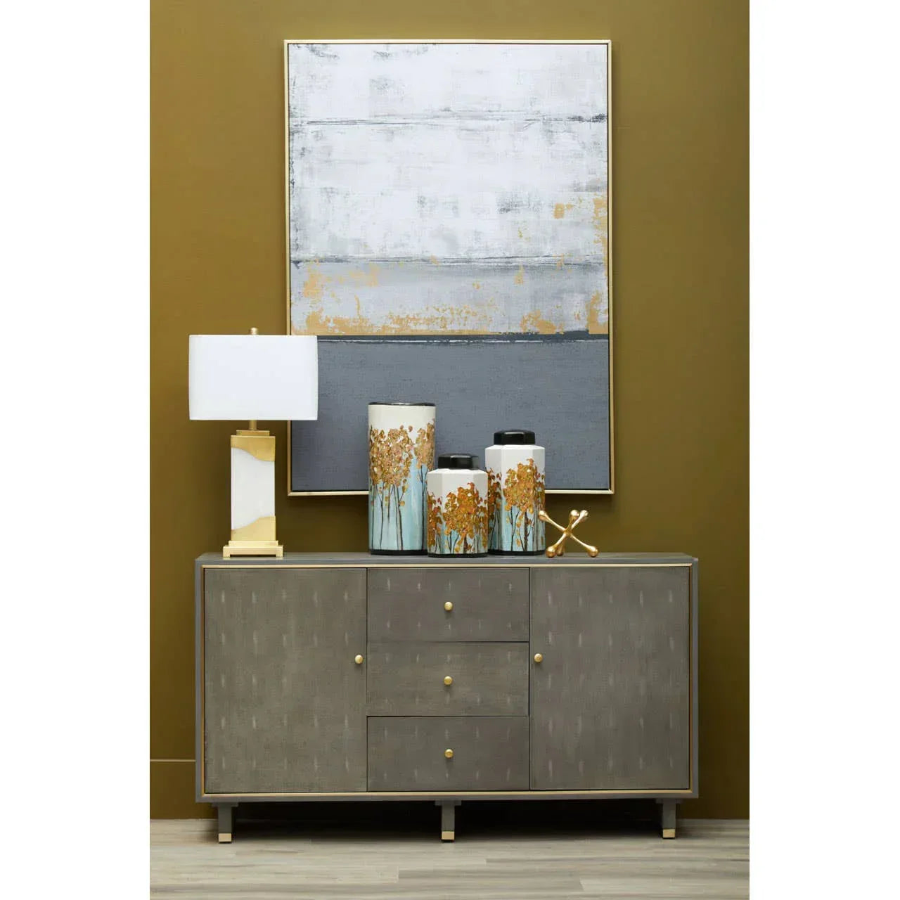 Grey sideboard with gold handles, decorative vases, table lamp and abstract wall art
