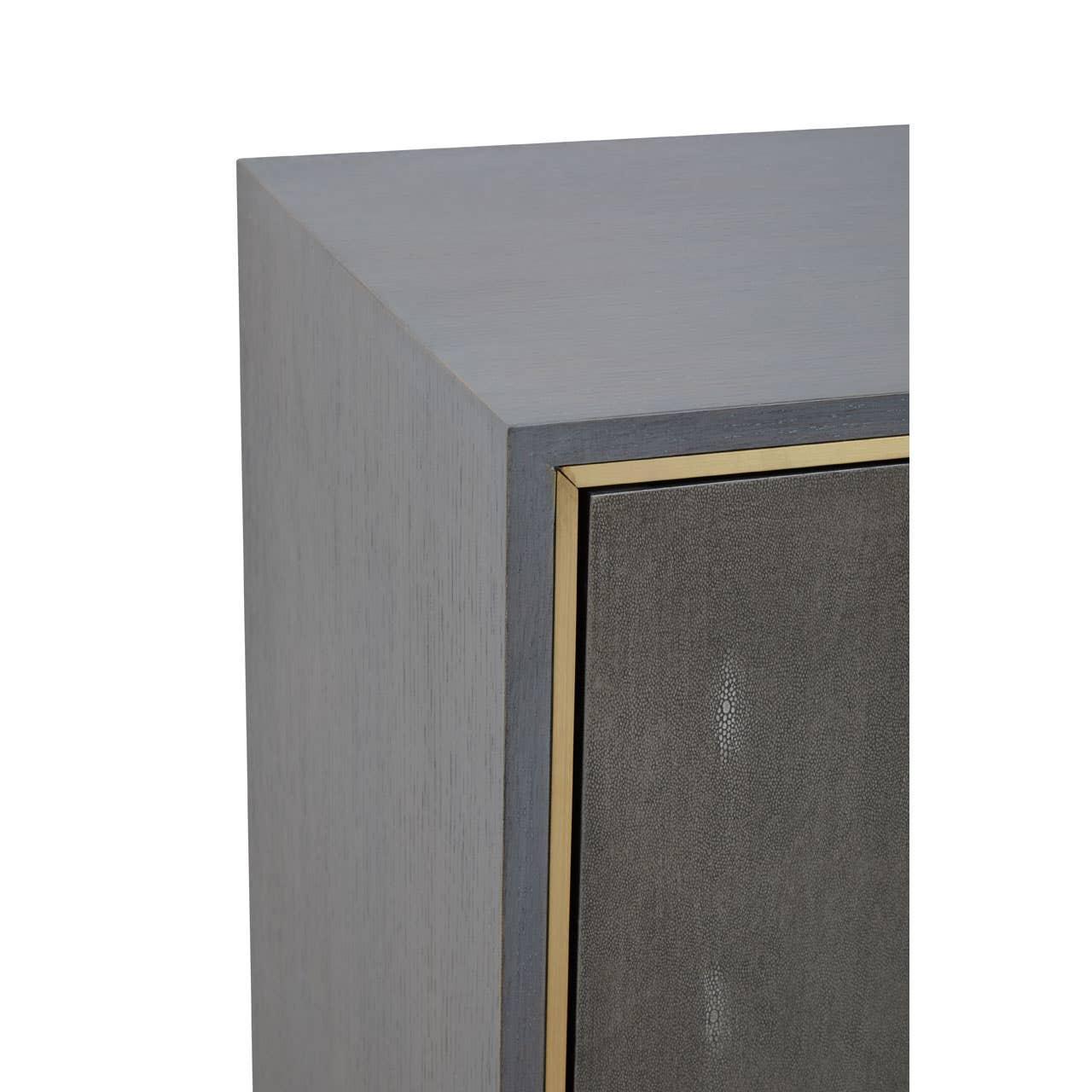 Grey wood cabinet corner with textured panel and brass trim detail