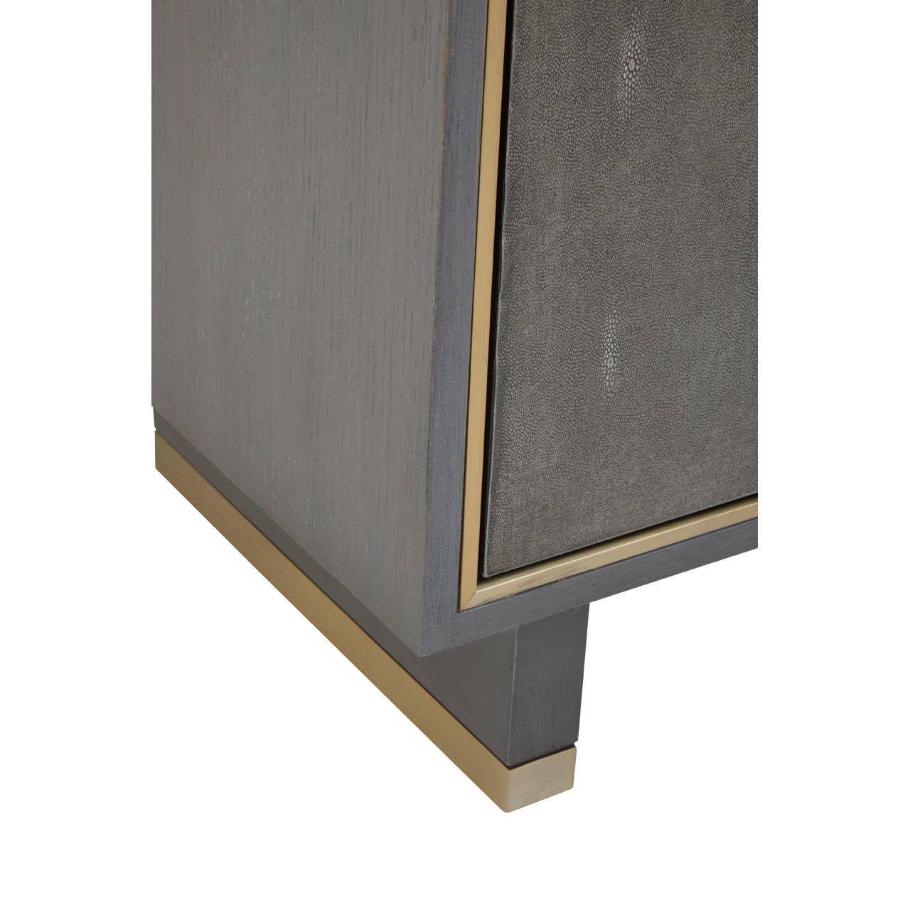 Close-up of wooden cabinet corner with gold trim and textured grey panel
