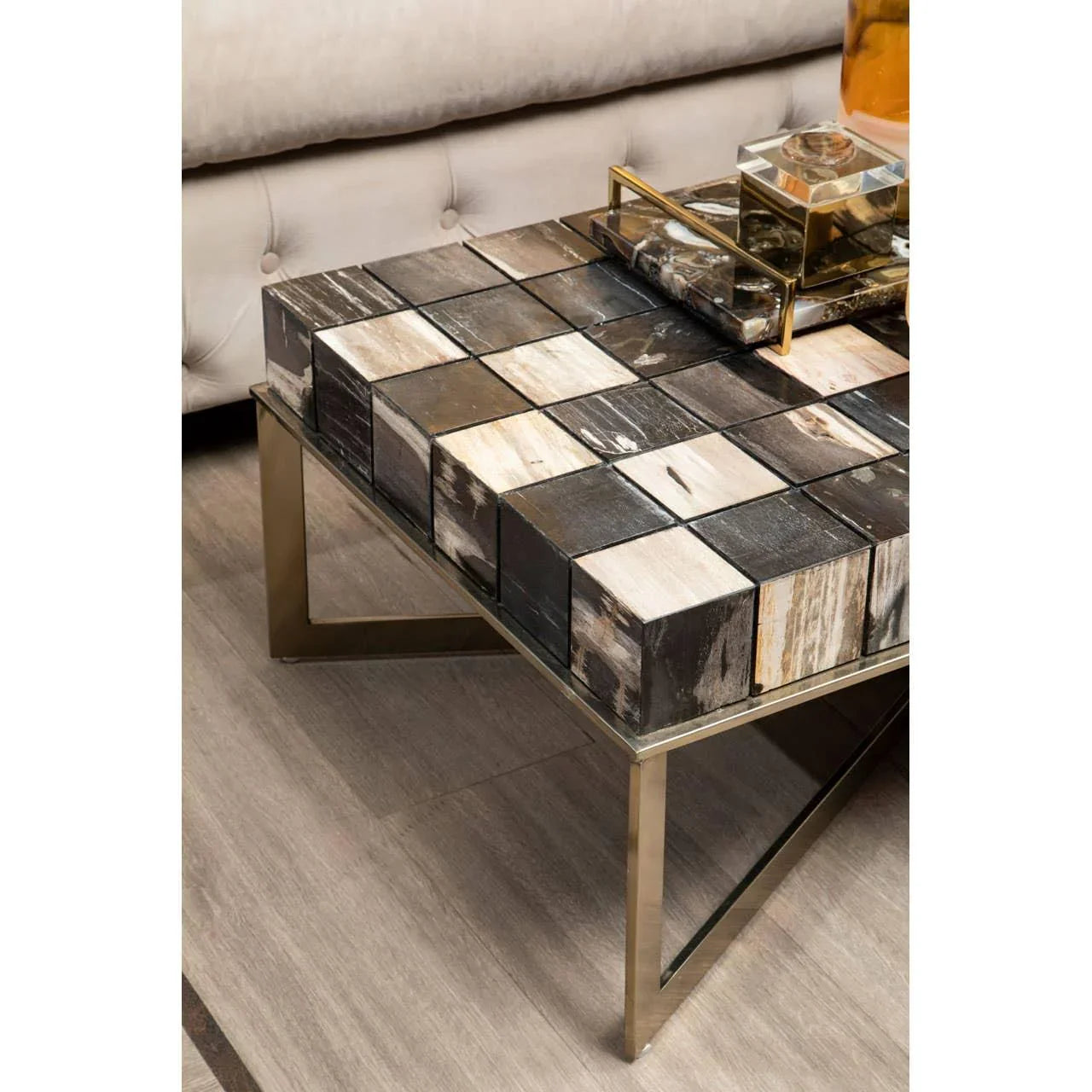 Modern coffee table with block-patterned wood top and gold metal legs in living room