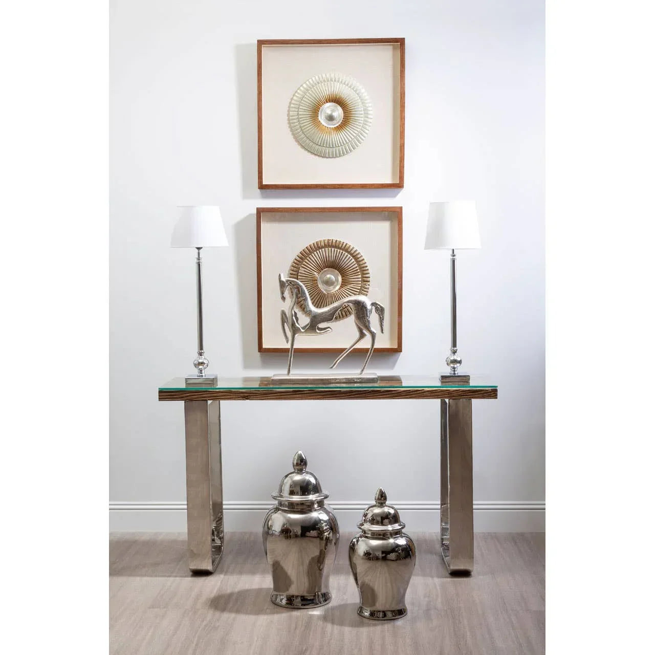 Glass console table with chrome legs, silver horse sculpture, and two metallic ginger jars