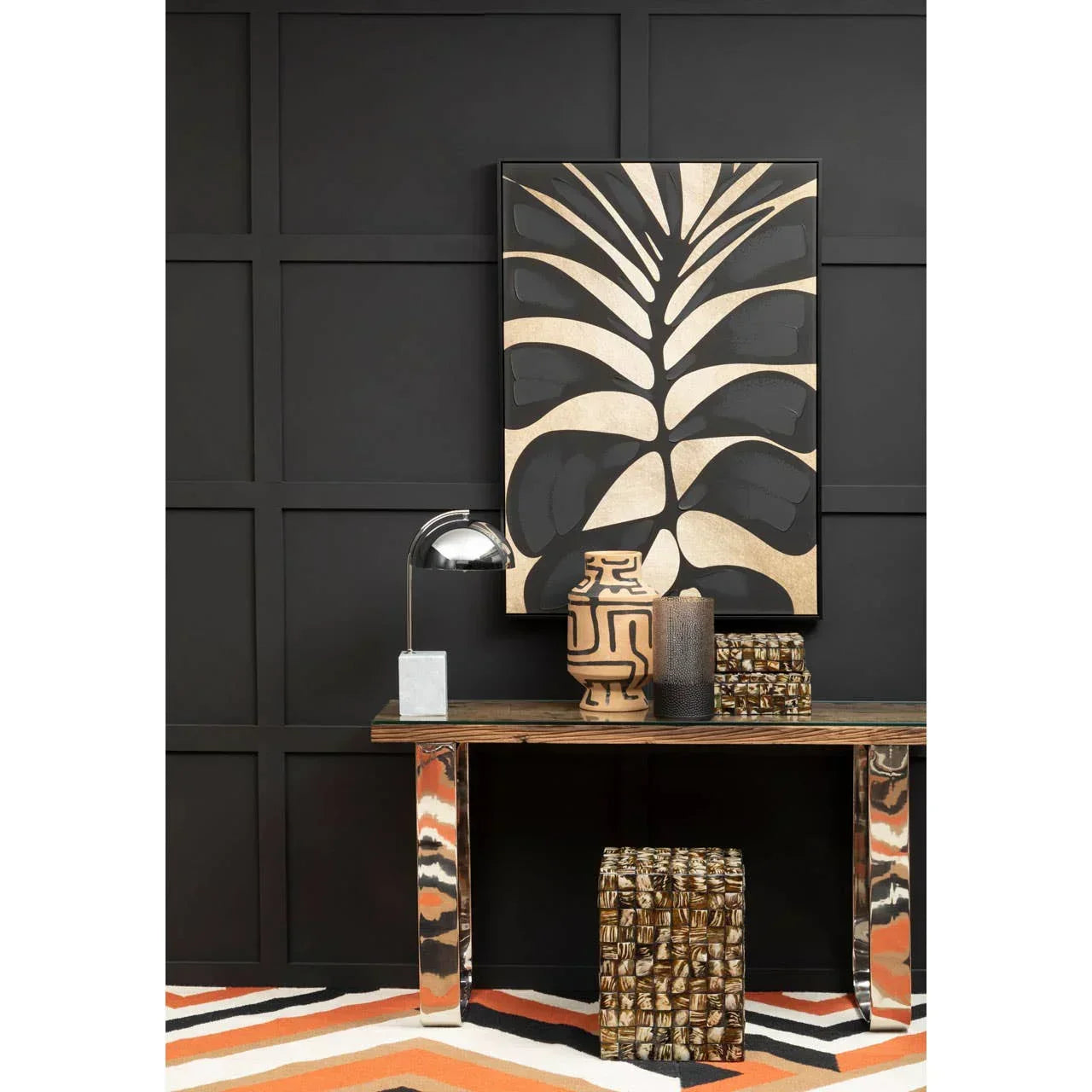 Modern console table with metallic legs, decorative vases, and abstract wall art in hallway