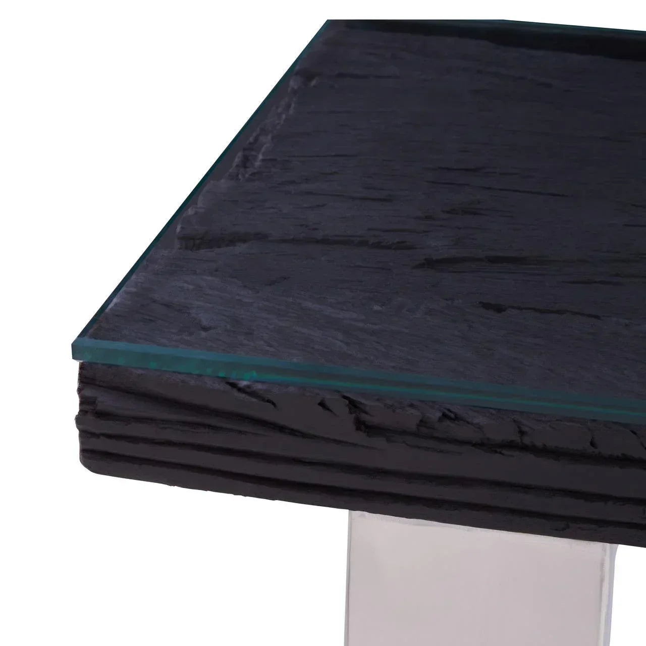 Glass top dining table with textured black stone edge and chrome leg closeup