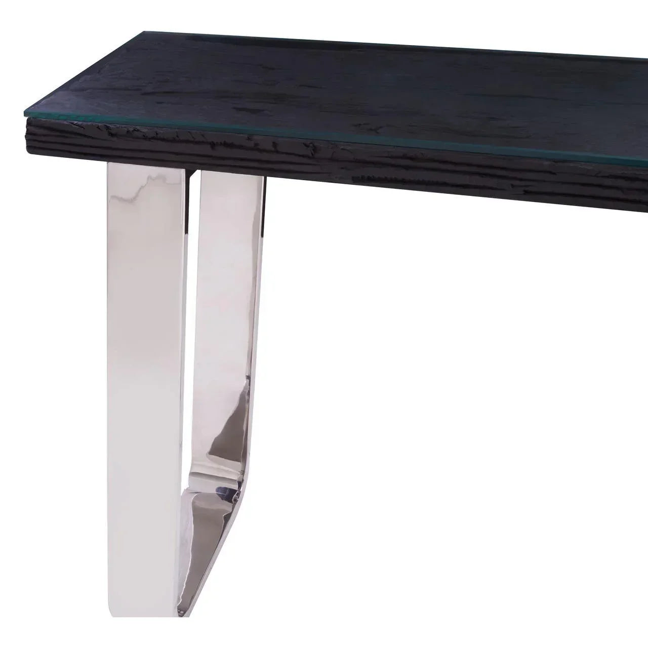 Modern dining table with black wood top and chrome metal legs, close-up corner view