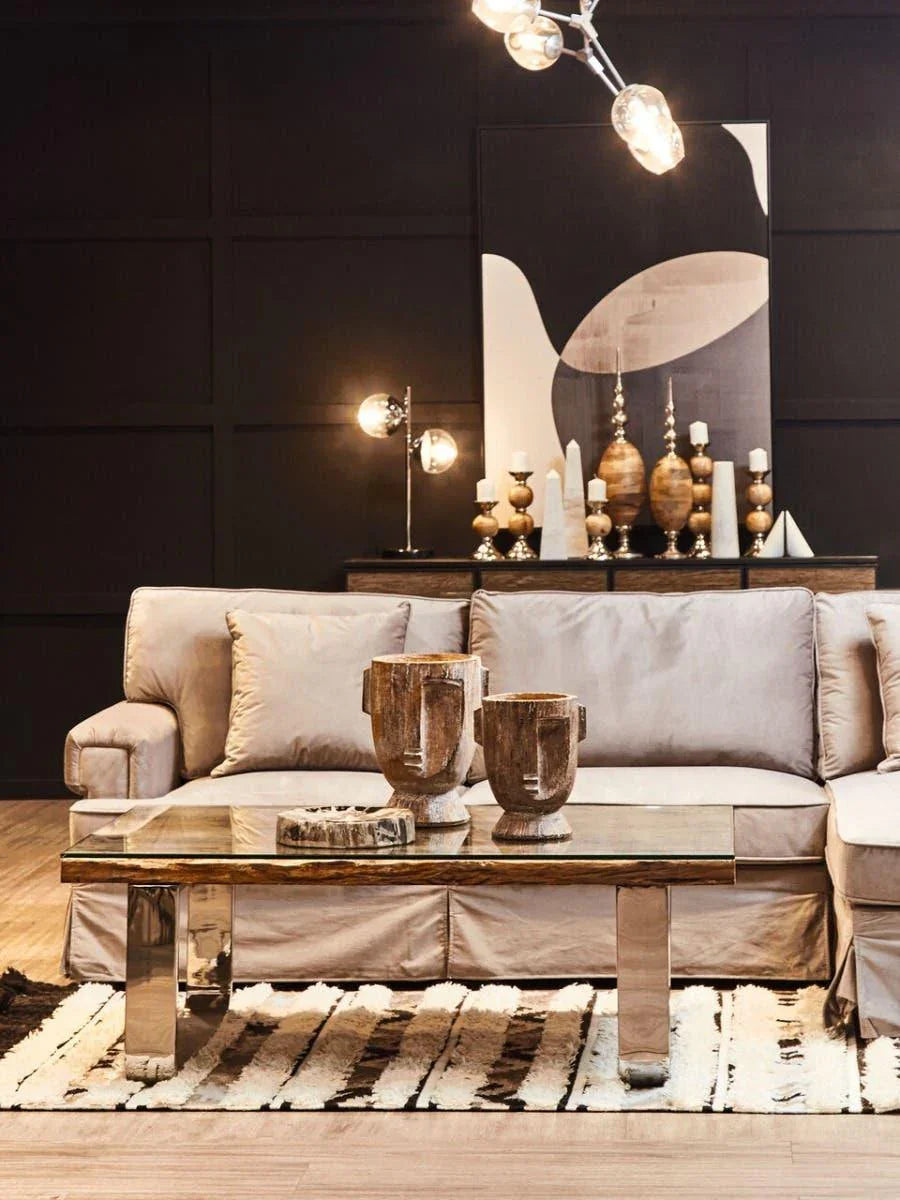 Modern beige sofa with glass coffee table and wooden decor in contemporary living room