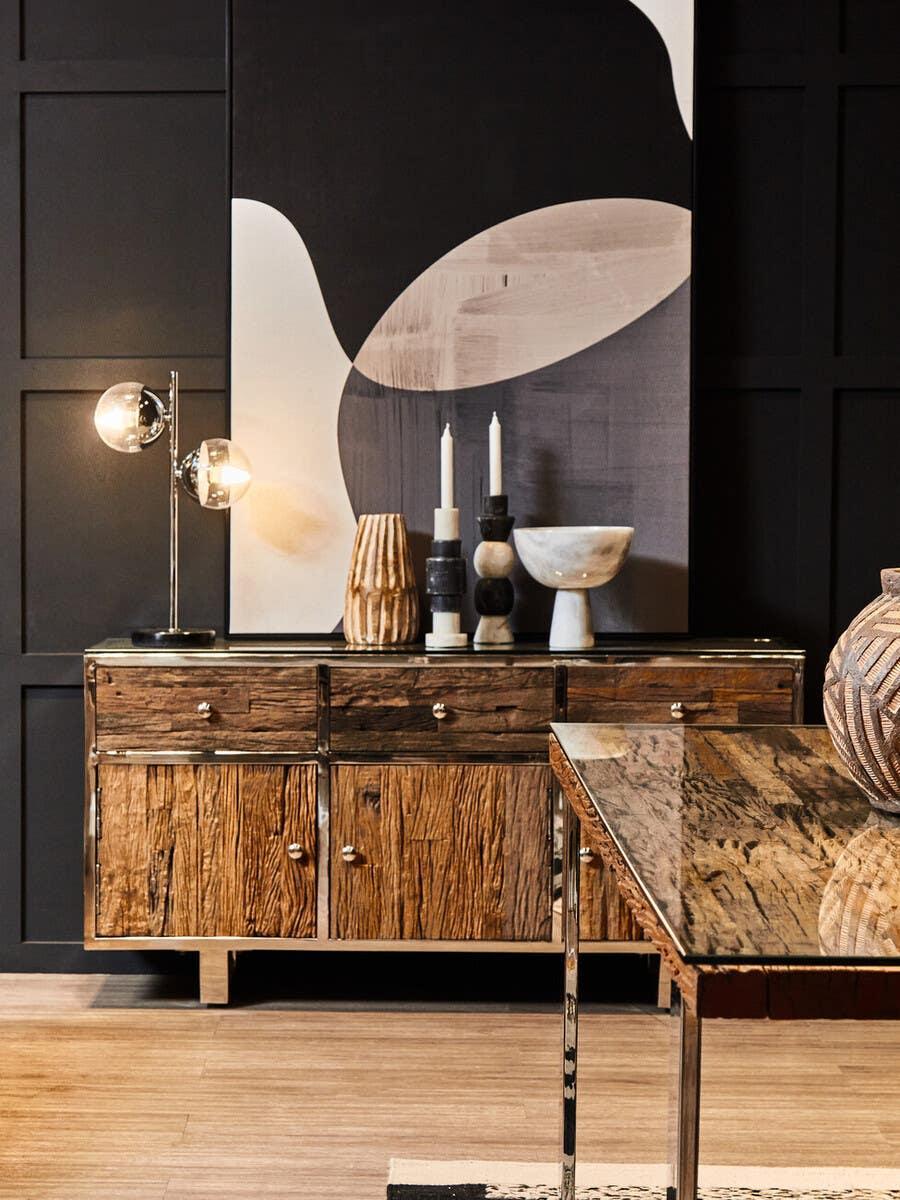 Rustic wood sideboard with metal trim, lamp, decorative vases and modern abstract art