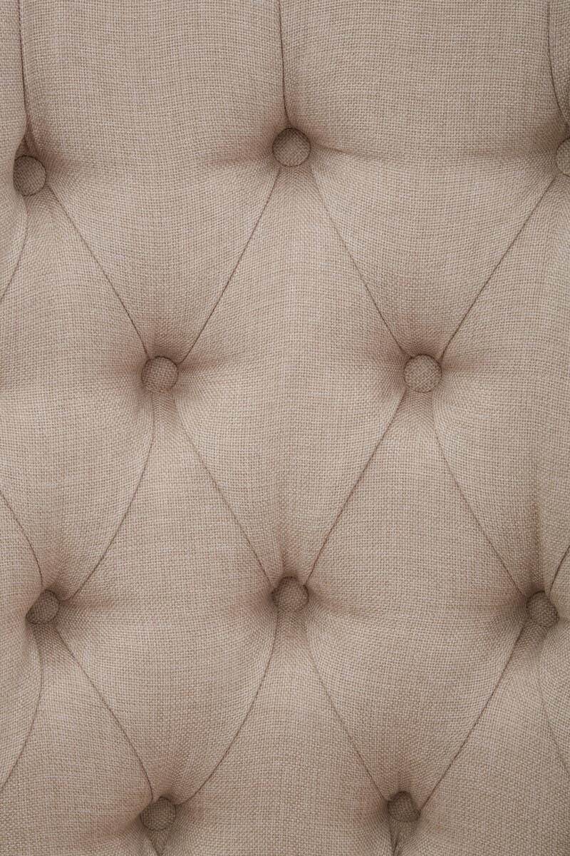 Beige linen upholstered sofa button-tufted detail close-up