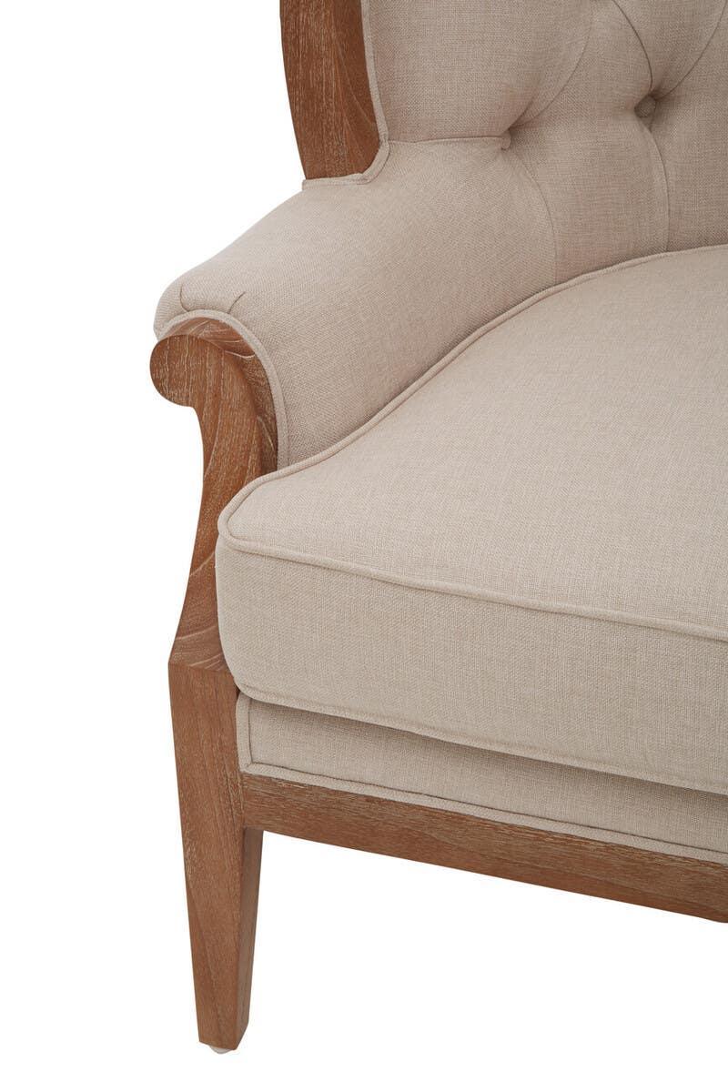 Beige fabric armchair with wooden frame and tufted backrest, corner closeup view