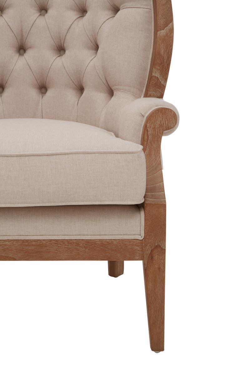 Beige upholstered armchair with button-tufted back and light wood frame, front side view