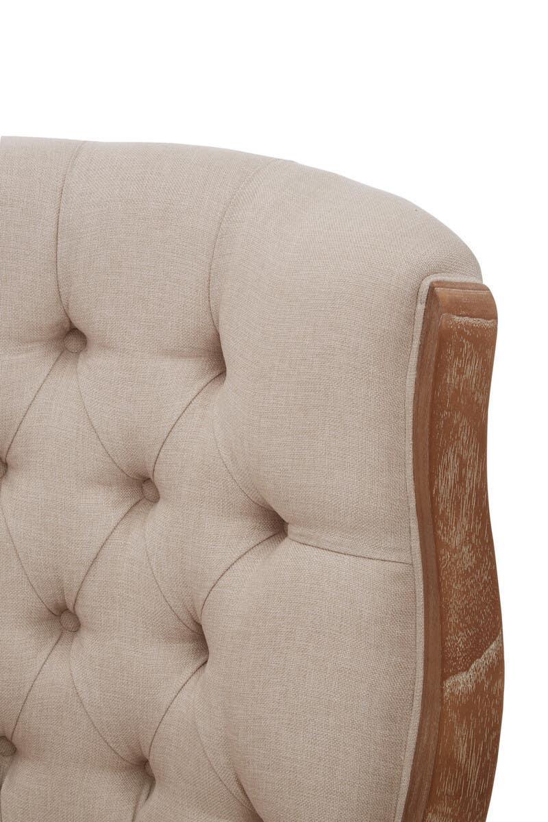 Beige fabric upholstered sofa backrest with button tufting and exposed wooden frame detail