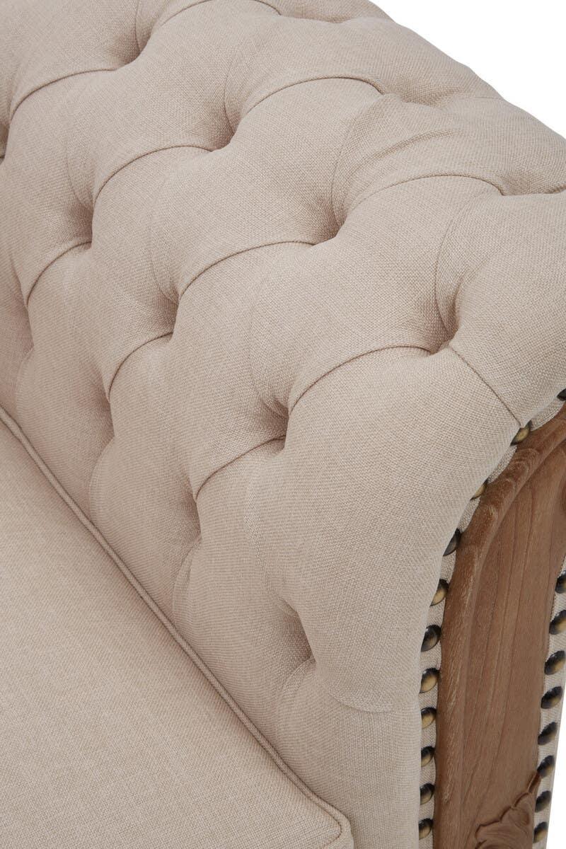 Beige fabric sofa arm with deep button tufting and wooden trim detail