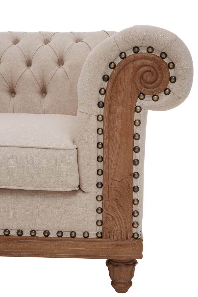 Beige fabric sofa with deep button tufting and carved wood scroll armrest detail
