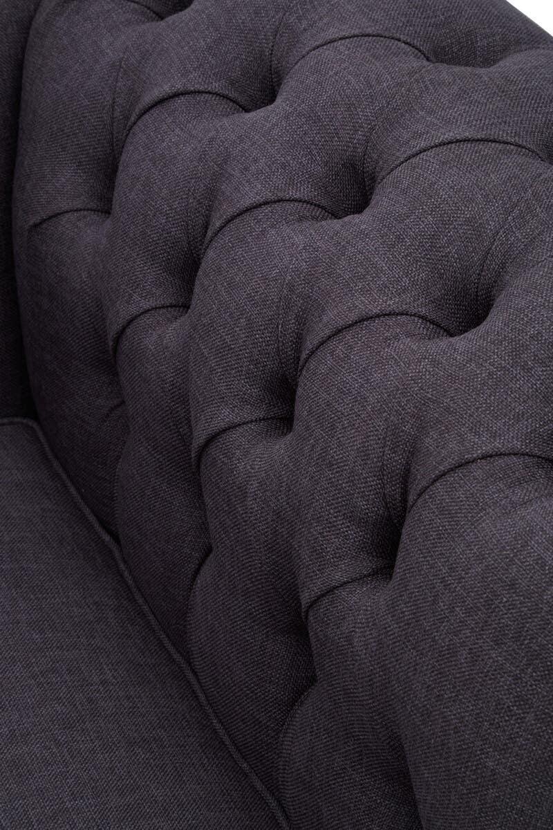 Dark grey fabric sofa with deep button tufted backrest close-up