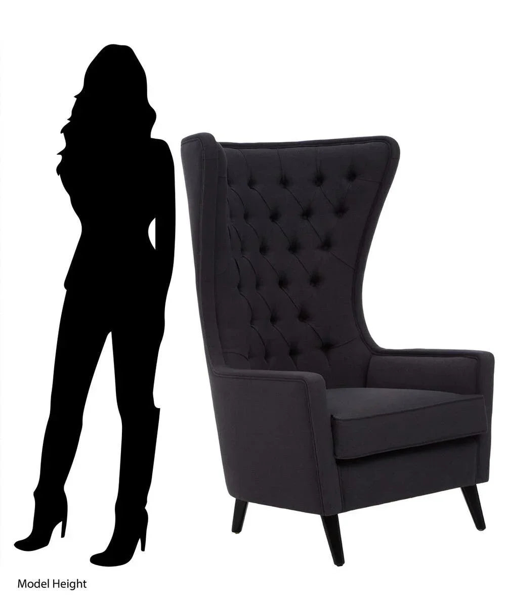 Dark grey high back armchair with button tufting and model silhouette for size comparison