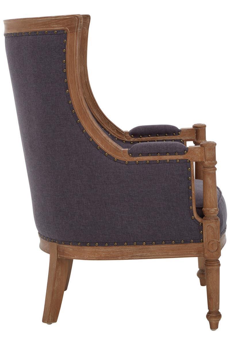 Side view of upholstered armchair with dark fabric and exposed wooden frame with stud detailing