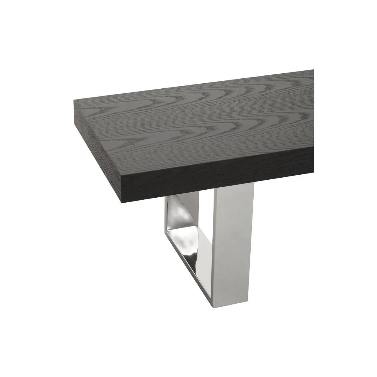 Dark wood dining table corner with stainless steel legs, close-up of surface grain detail