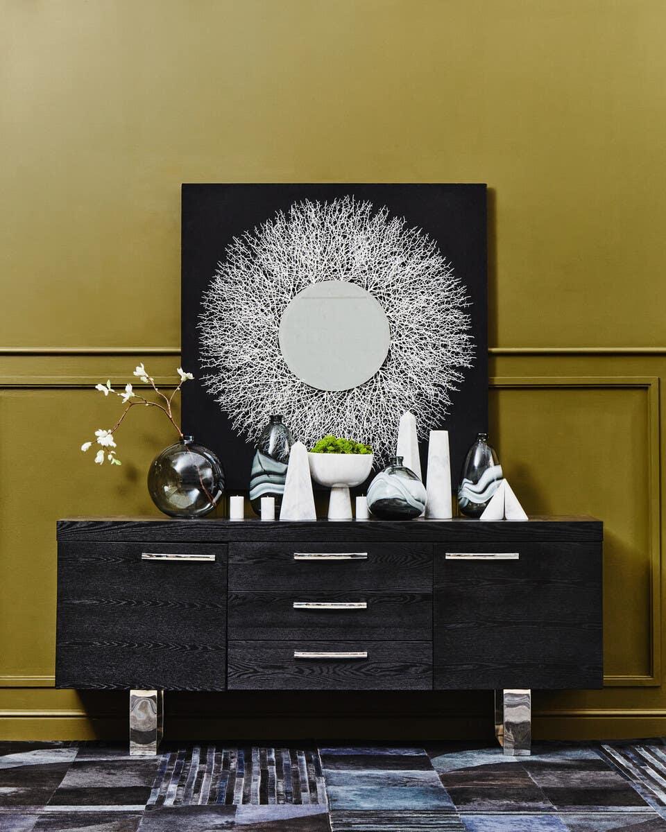 Black sideboard with chrome handles, decorative vases, and modern wall art above